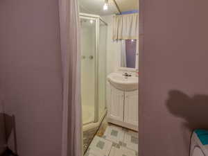 Bathroom featuring a shower stall, vanity, and tile patterned floors