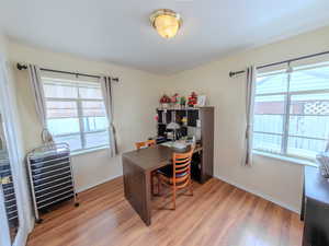 Bedroom used as home office with light wood-style flooring and baseboards