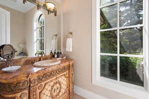 Bathroom with ornamental molding and vanity