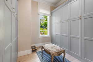 Mudroom featuring ornamental molding, baseboards, and wood finished floors