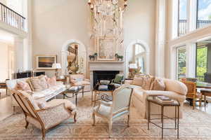 Living area with a towering ceiling, a fireplace, and a chandelier