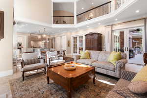 Living area featuring a towering ceiling, recessed lighting, baseboards, and ornamental molding