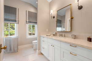 Bathroom with vanity, baseboards, toilet, and tile patterned flooring