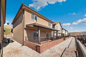 Rear view of property featuring stucco siding, central AC unit, and a residential view