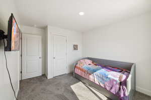 Carpeted bedroom with baseboards and recessed lighting