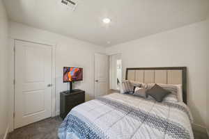 Bedroom with dark carpet and baseboards