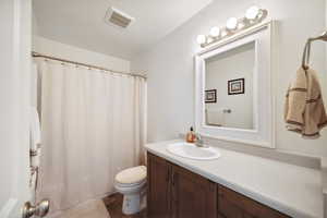 Full bath with toilet, vanity, a shower with shower curtain, and tile patterned floors