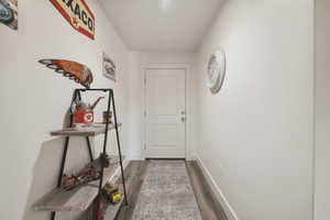 Doorway to outside featuring wood finished floors and baseboards