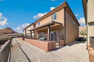 Rear view of property with stucco siding and fence