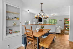 Dining room with a chandelier, light wood-type flooring, baseboards, and breakfast area