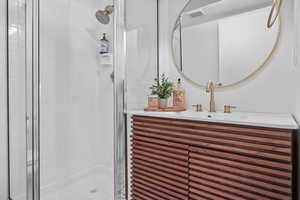 Bathroom with a shower stall and vanity