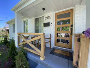 View of exterior entry with a porch and brick siding