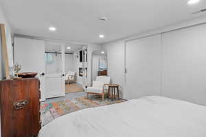 Bedroom with recessed lighting, a closet, connected bathroom, and wood finished floors