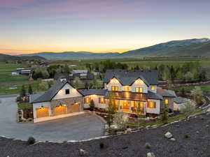 View of front facade with driveway, an attached garage, a mountain view, and stone siding