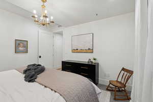 Bedroom featuring baseboards, a chandelier, and carpet floors