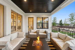 Balcony featuring an outdoor living space with a fire pit