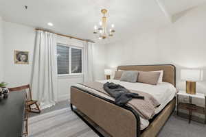 Bedroom featuring light colored carpet and a chandelier