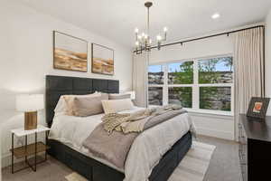 Bedroom featuring light colored carpet, a chandelier, and baseboards