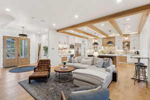 Living room featuring light wood-type flooring, recessed lighting, and beam ceiling