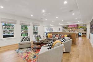 Living room with light wood finished floors, recessed lighting, and baseboards
