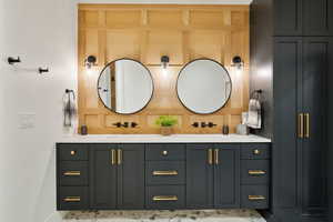 Bathroom with double vanity and baseboards