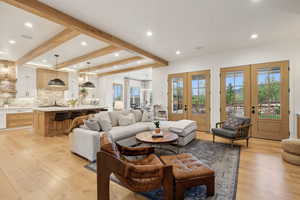 Living area featuring french doors, light wood-style floors, recessed lighting, and beamed ceiling
