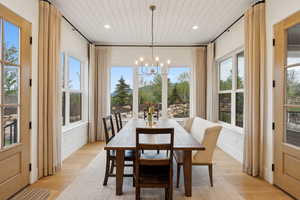 Dining space with a chandelier, wood ceiling, healthy amount of natural light, light wood finished floors, and recessed lighting