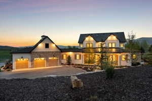 View of front of house featuring concrete driveway, an attached garage, and stone siding