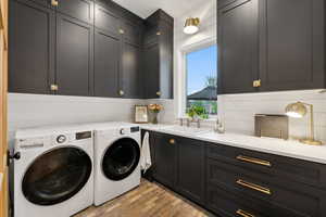 Washroom with cabinet space, washer and clothes dryer, and brick floors