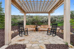 View of patio with a pergola and a wooded view