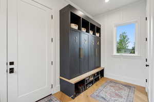 Mudroom with light wood-style flooring and baseboards