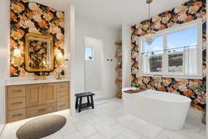 Bathroom featuring wallpapered walls, a chandelier, marble finish floors, plenty of natural light, and a walk in shower