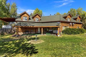 Back of property with a shingled roof, log exterior, and a patio