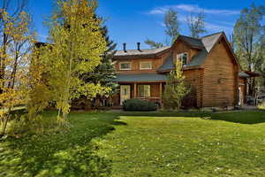 View of front of property with a front lawn and log siding