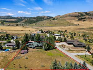 Aerial overview of property's location featuring property parcel outlined and a mountainous background