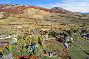 Aerial view of property's location with property parcel outlined and a mountain backdrop