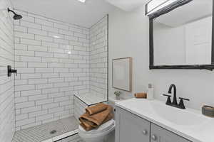 Bathroom with toilet, a shower stall, and vanity