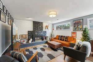 Living room featuring wood finished floors and a brick fireplace