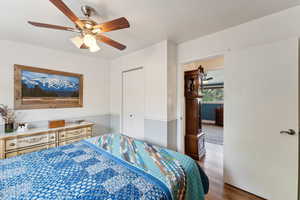 Bedroom featuring wood finished floors, ceiling fan, and a closet