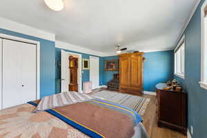 Bedroom with wood finished floors, a closet, baseboards, and a ceiling fan
