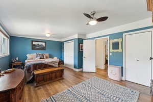 Bedroom with wood finished floors, a closet, ceiling fan, and baseboards