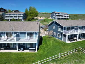 Rear view of property featuring a patio and a shingled roof