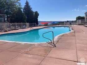 Community pool with a patio and fence