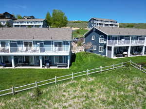 Rear view of property featuring a patio and roof with shingles