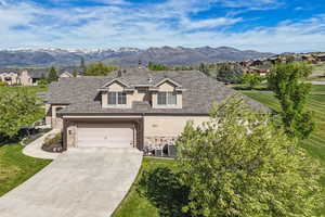 View of front facade featuring stucco siding, stone siding, driveway, and a garage
