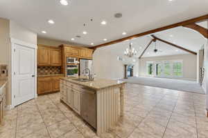 Kitchen with stainless steel appliances, a sink, recessed lighting, light carpet, and open floor plan
