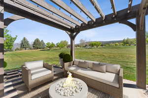 View of patio with a pergola, an outdoor living space with a fire pit, and a mountain view