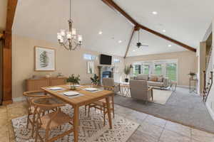 Dining room featuring beam ceiling, a glass covered fireplace, baseboards, light tile patterned floors, and light carpet