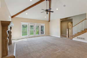 Unfurnished living room with high vaulted ceiling, arched walkways, carpet, a ceiling fan, and beamed ceiling