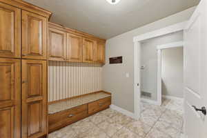 Mudroom with light tile patterned floors and baseboards
